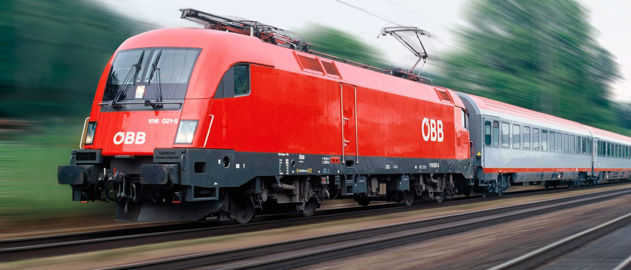 Austrian Train travels through scenic landscape