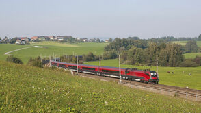 Railjet travels trhrough scenic landscape